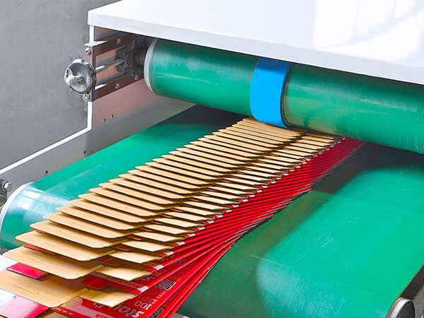  a batch of printed boxes coming out from an automatic gluing machine