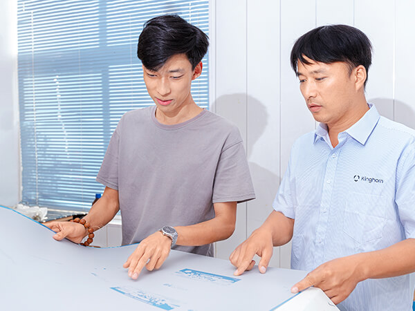 2 technicians holding a plate and discussing plate making workshop