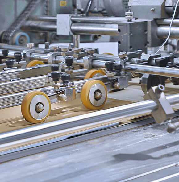 a piece of cardboard with printed graphic is being cut by the auto die cutting machine