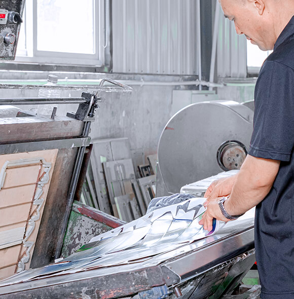 a worker is operating a manual die cutting machine