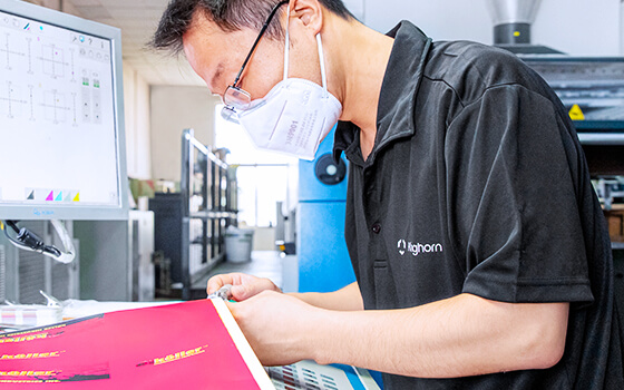 an inspector is checking the color deviation of a printed product